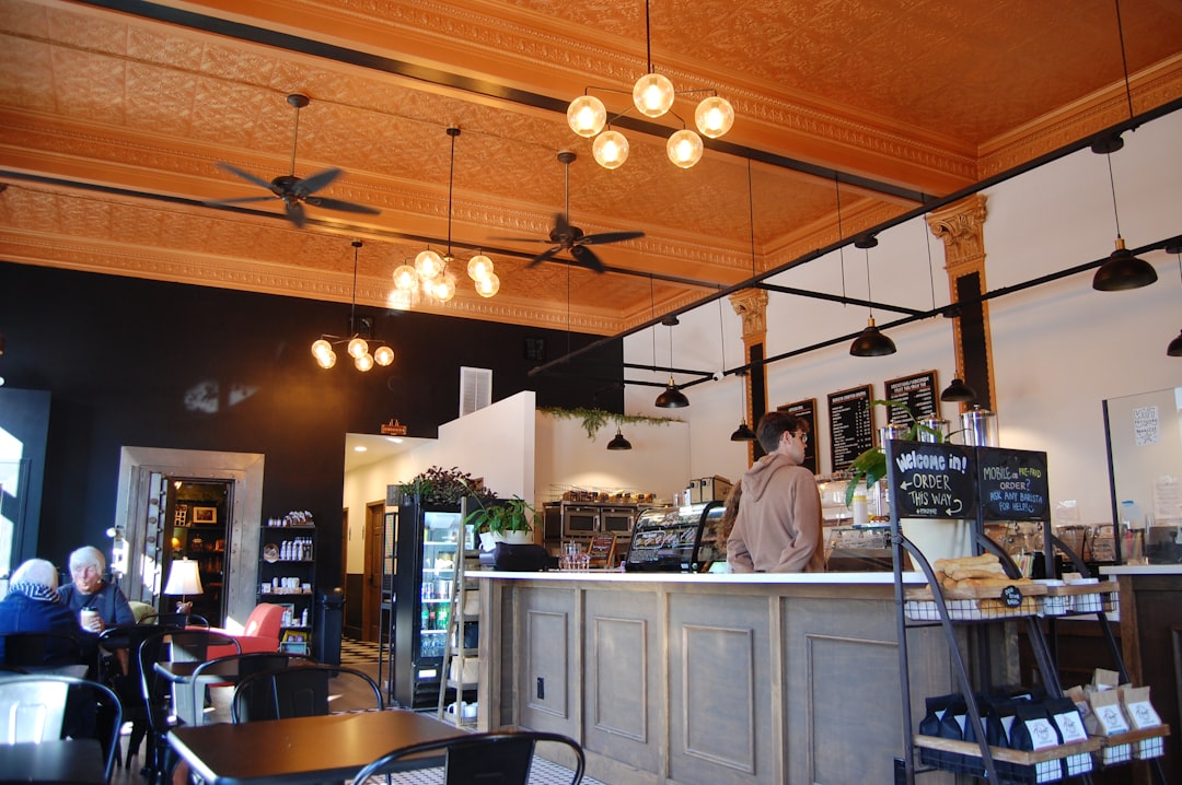 Spacious coffee shop interior with ornate ceiling and counter.