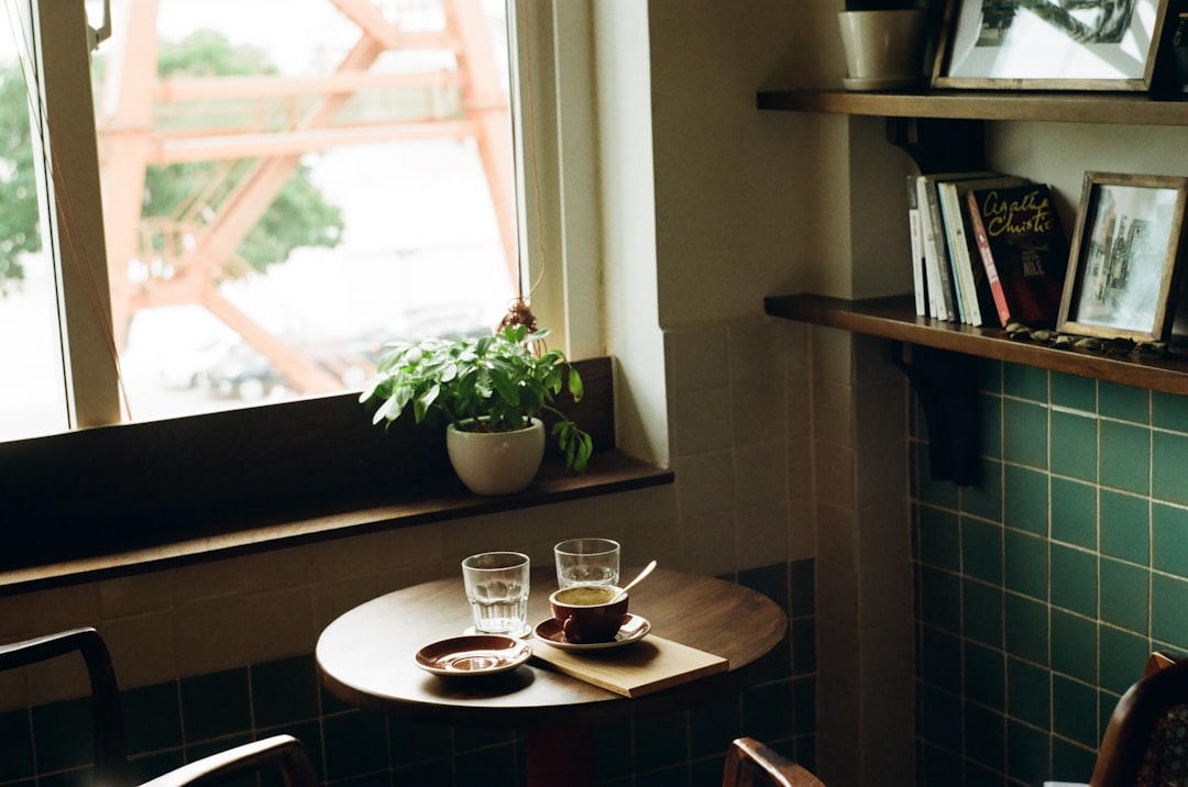 filled white cup on top of white saucer surrounded by coffee beans